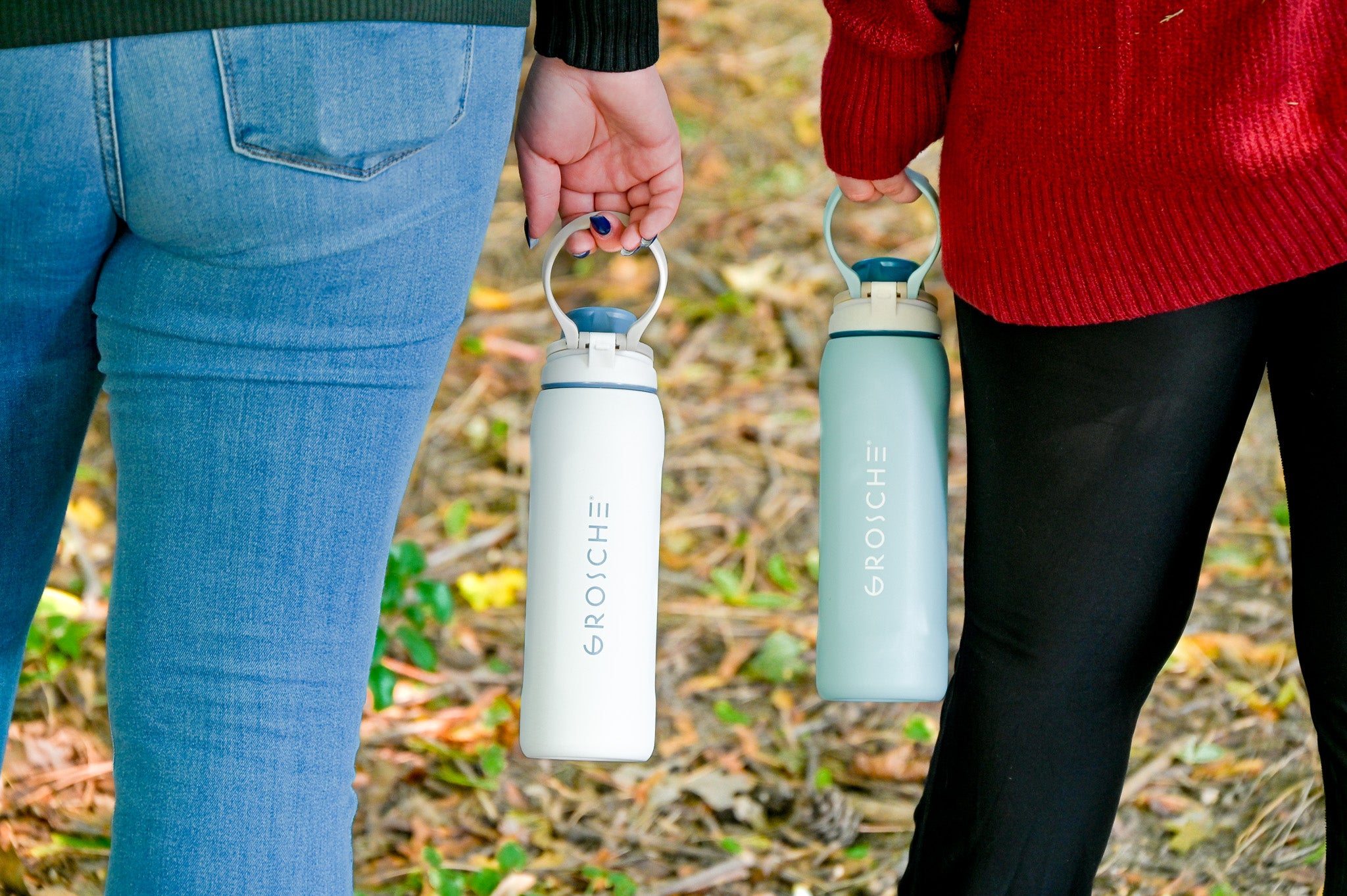 GROSCHE Kamloops Two people standing next to each other, holding a white and light blue water bottles outdoors.