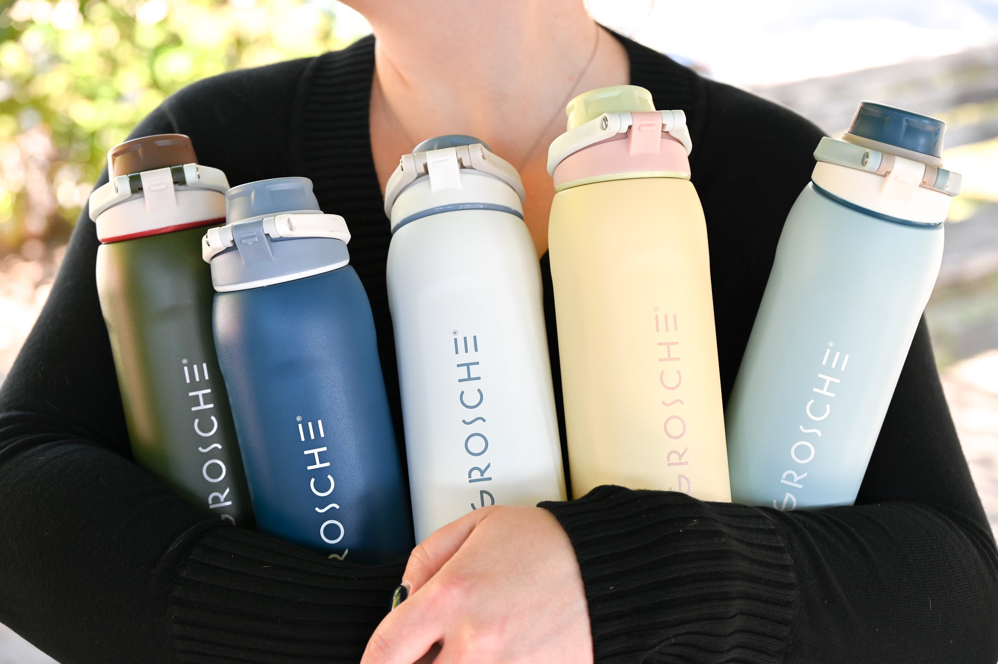 GROSCHE Kamloops Person holding five colorful water bottles with 'GROSCHE' branding facing outwards.