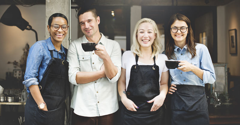 living wage baristas outside a coffee shop happy not in poverty