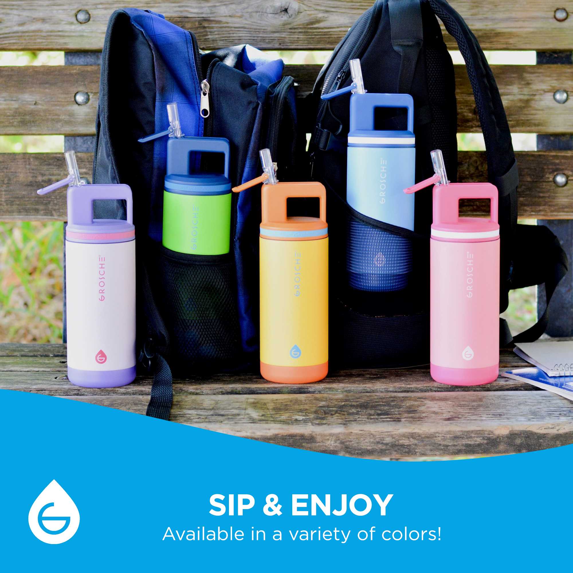 Five Alpine Kids bottles sitting n front of two backpacks on a park bench. Sip and enjoy, the Alpine Kids bottle is available in a variety of colours. 