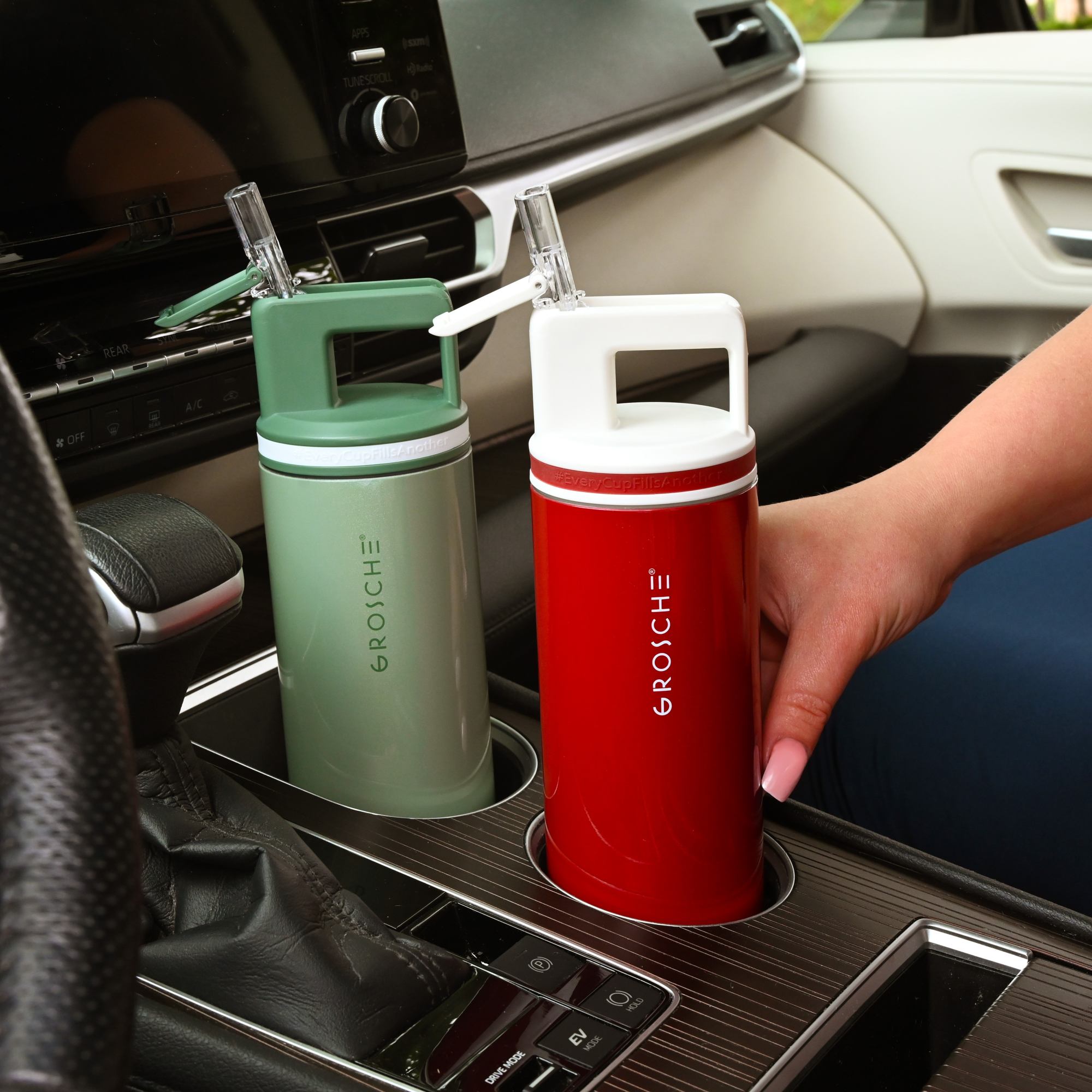 Red and green Grosche water bottles in a car cup holder