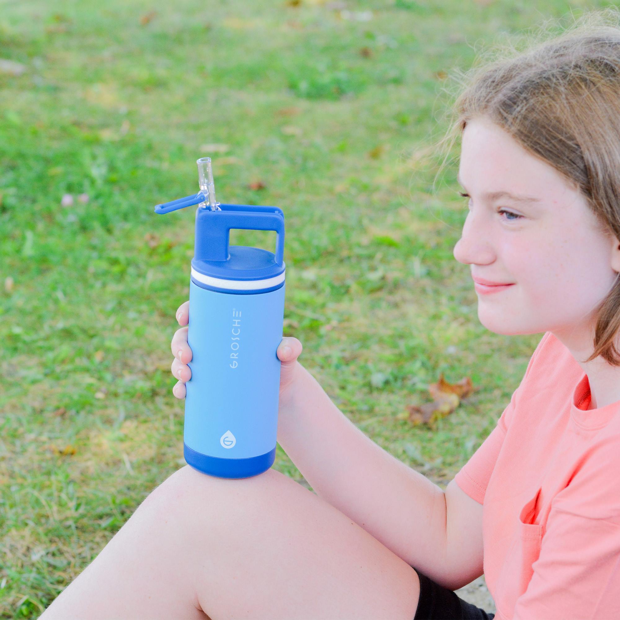A girl holding the alpine 16oz kids insulated water bottle in Scuba Blue.