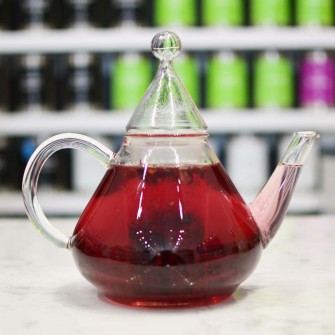 Grosche-Merlin-glass-infuser-teapot-with-red-tea-on-counter-top-marble