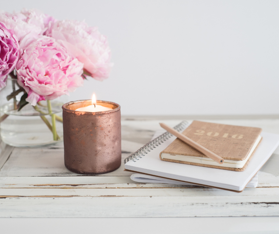 Image of a lit candle next to a journal